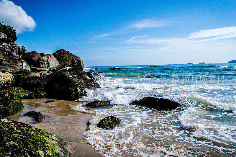 Itaguaçu Beach in São Francisco do Sul in Santa Catarina Brazil, with a rough sea hitting the water on the rocks